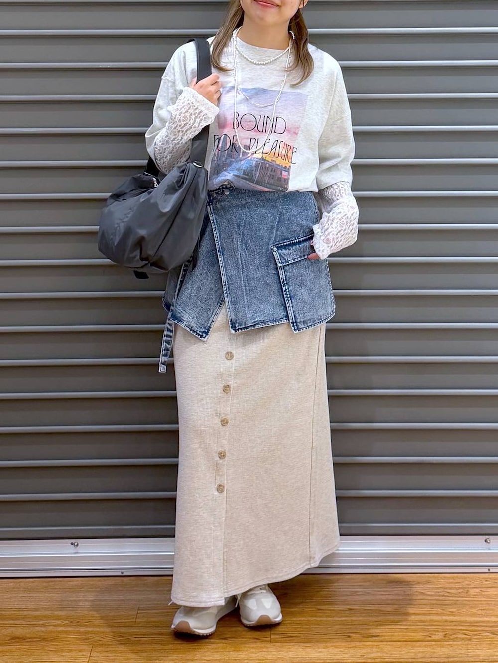 ベージュ系のスカート、ホワイト系のスニーカー、グレー系のショルダーバッグを着用したレディースの春コーディネートの5枚目の写真