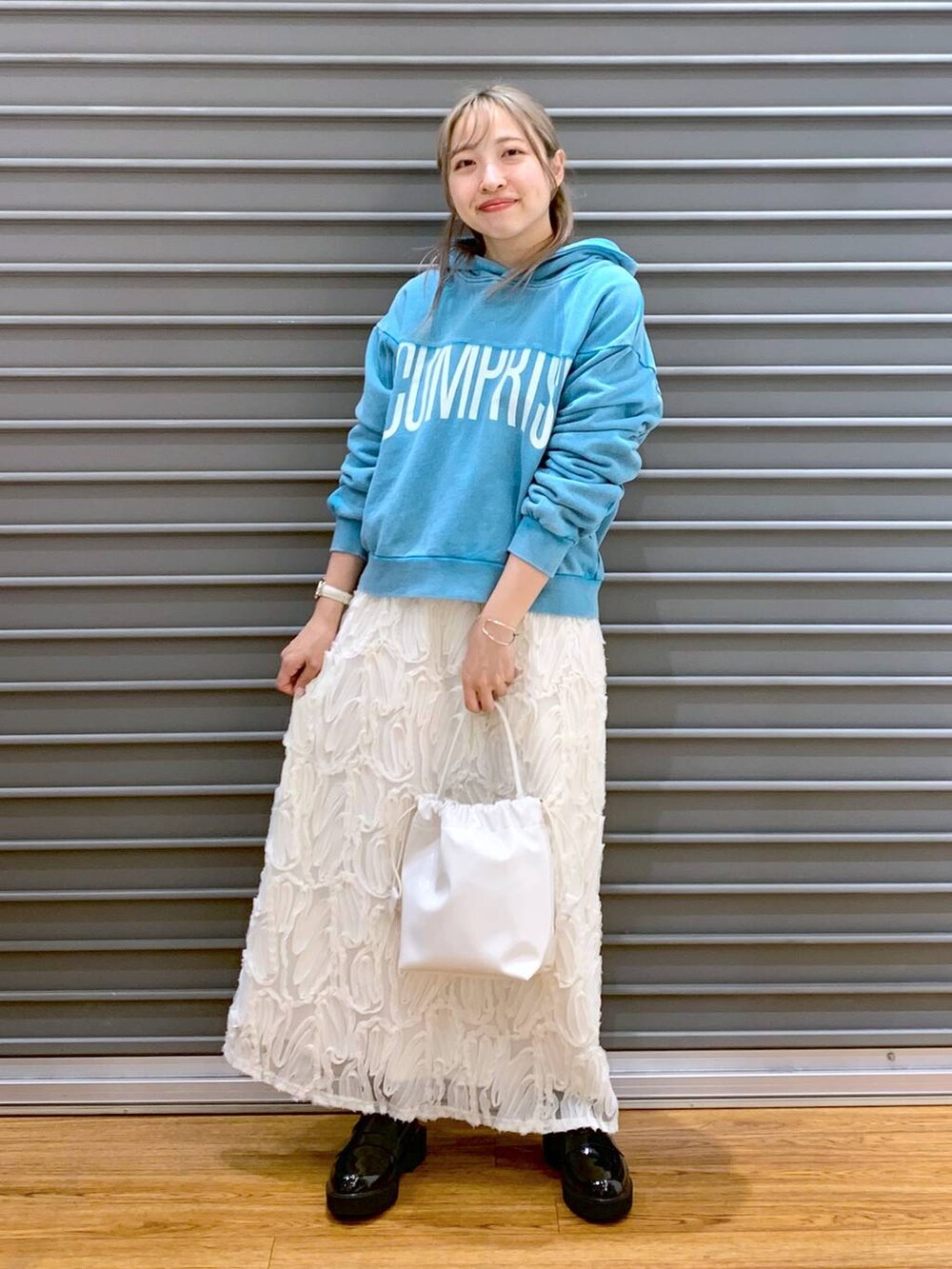 ブルー系のパーカー、ホワイト系のスカート、ブラック系のローファーを着用したレディースの冬コーディネートの7枚目の写真