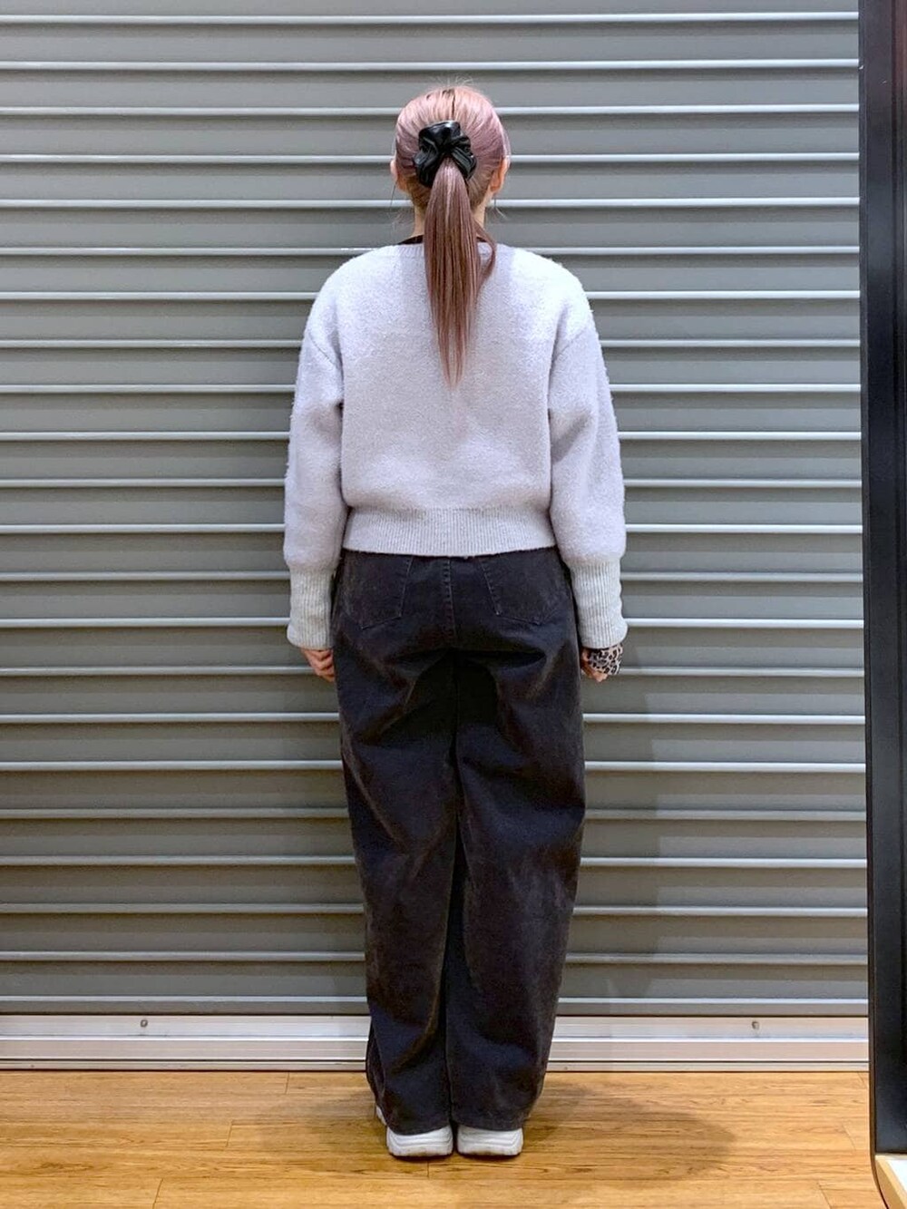 ブラック系のTシャツ/カットソー、ブラック系のショルダーバッグ、グレー系のデニムパンツを着用したレディースの冬コーディネートの2枚目の写真