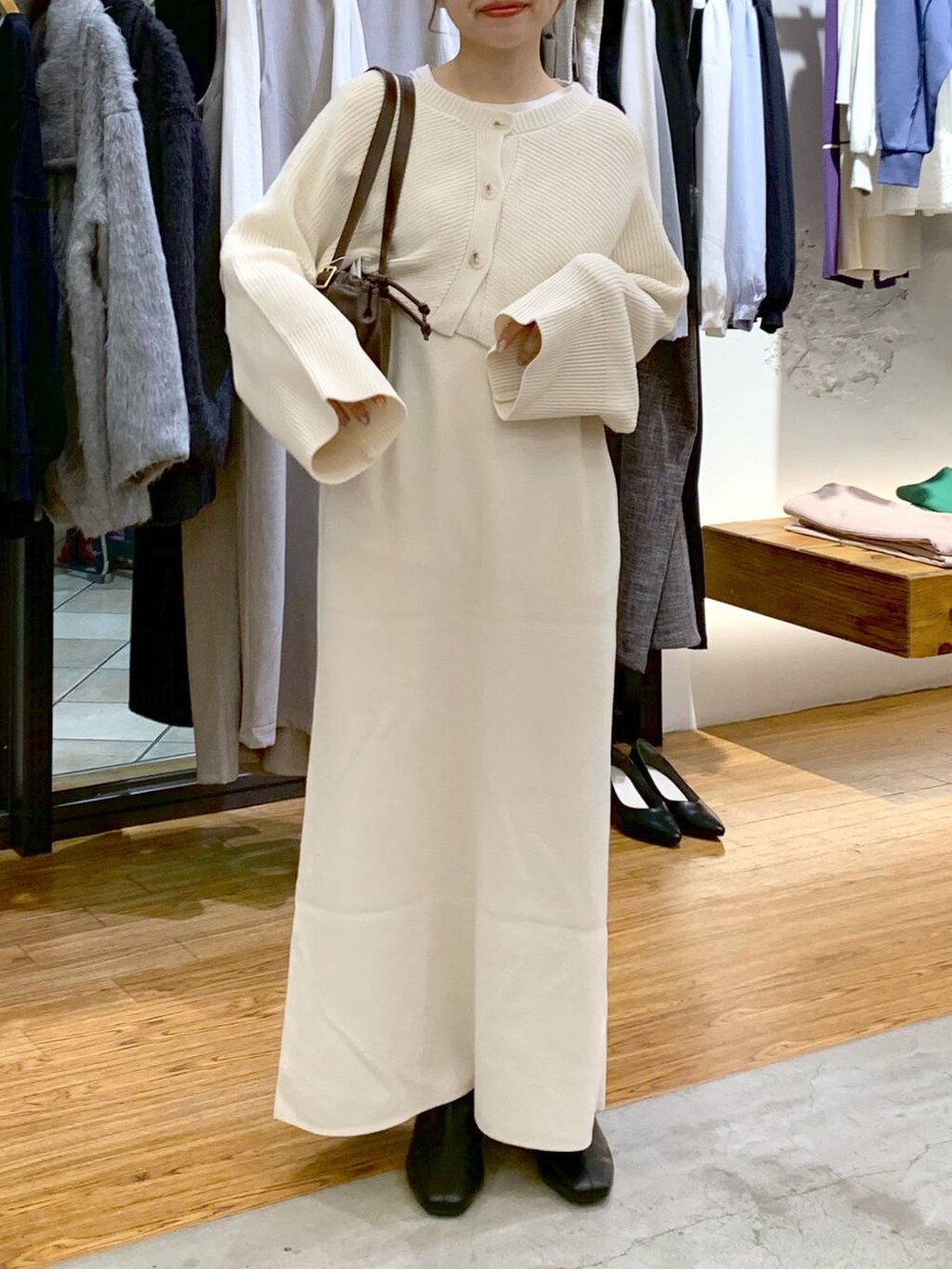 ブラック系のブーツ、ホワイト系のワンピース、ブラウン系のショルダーバッグを着用したレディースの冬コーディネートの3枚目の写真