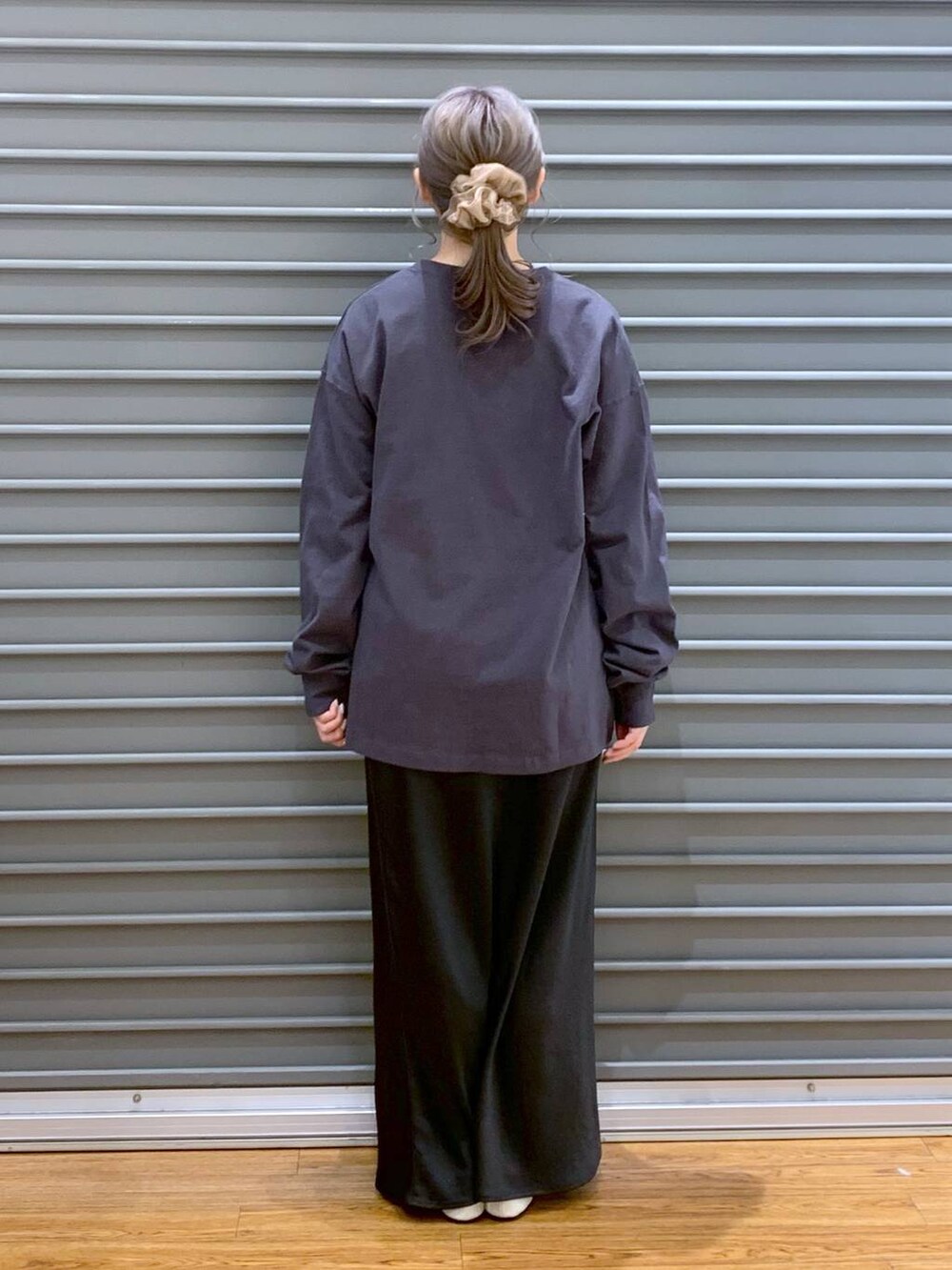 ブラック系のスカート、ホワイト系のパンプス、グレー系のTシャツ/カットソーを着用したレディースの春コーディネートの2枚目の写真