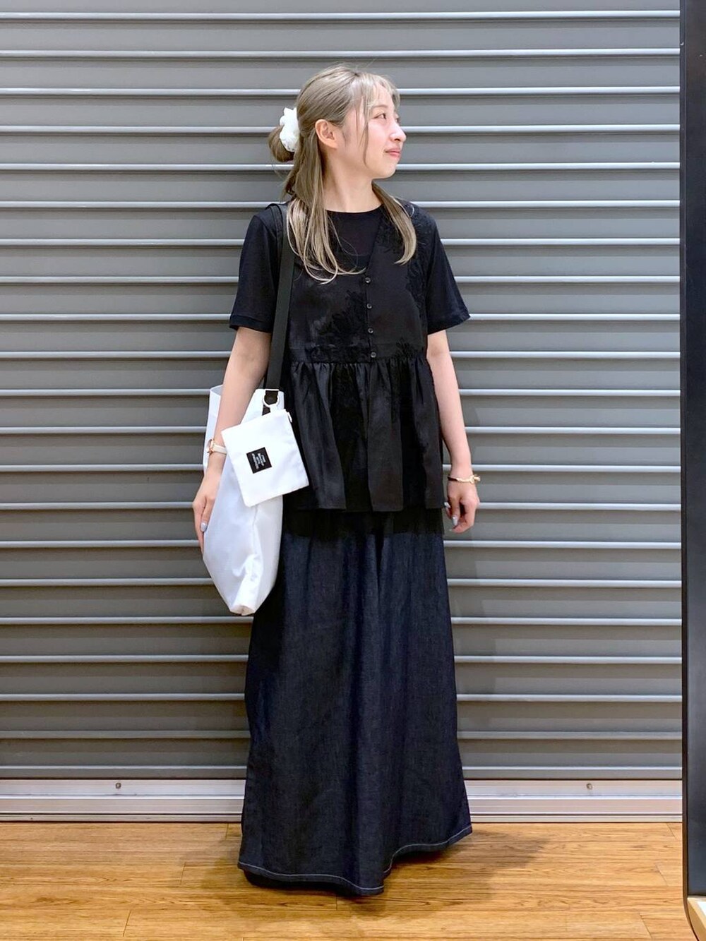 ブラック系のサンダル、ブルー系のデニムパンツ、ブラック系のシャツ/ブラウスを着用したレディースの夏コーディネートの4枚目の写真