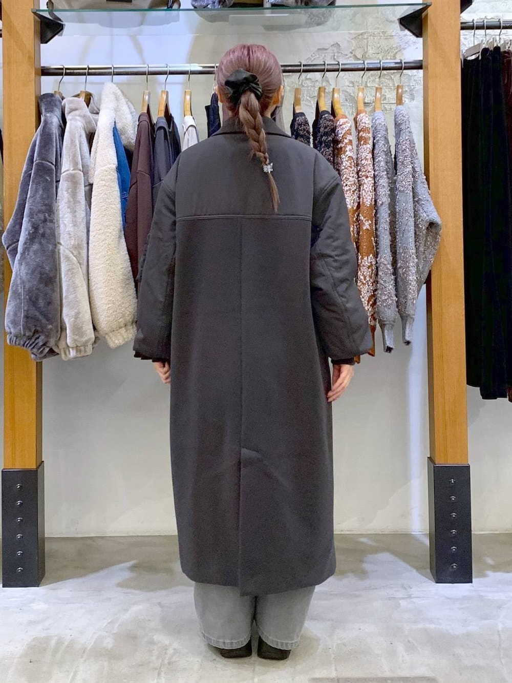 ブラック系のブーツ、ブラック系のショルダーバッグ、グレー系のその他アウターを着用したレディースの冬コーディネートの2枚目の写真