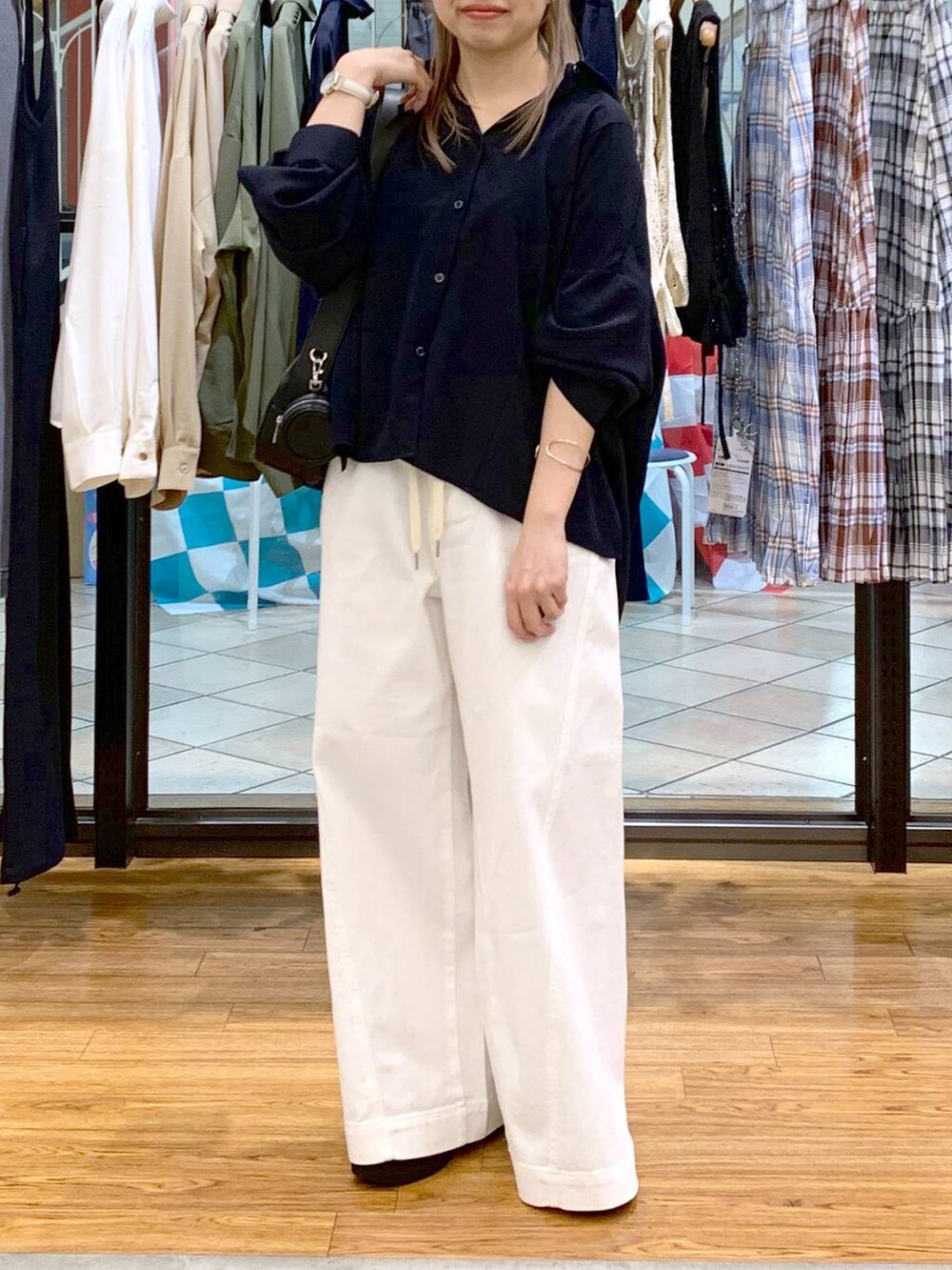 ブルー系のシャツ/ブラウス、ブラック系のローファー、ホワイト系のデニムパンツを着用したレディースの春コーディネートの4枚目の写真