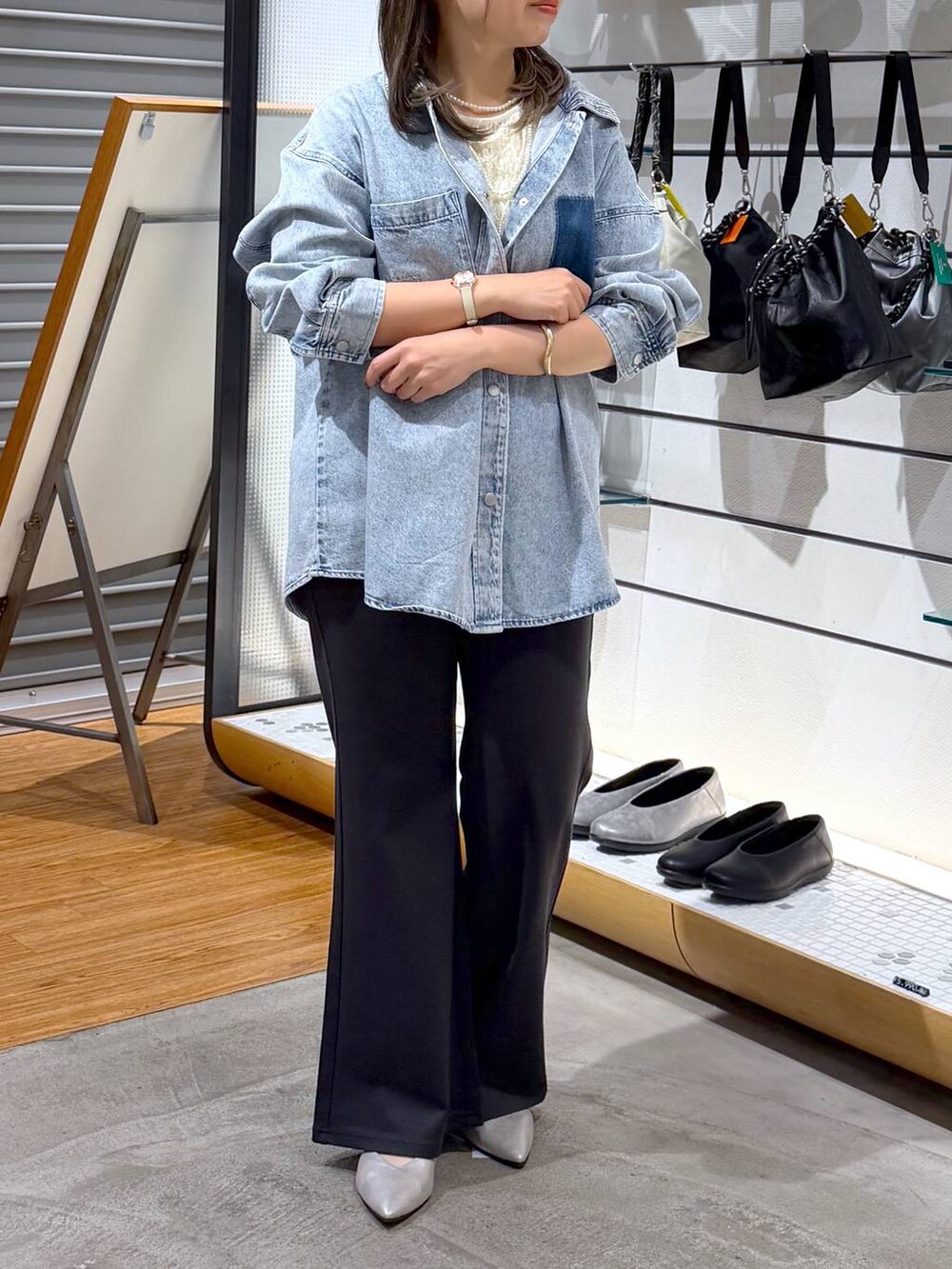 ブラック系のボストンバッグ、シルバー系のパンプス、ブルー系のシャツ/ブラウスを着用したレディースの冬コーディネートの5枚目の写真