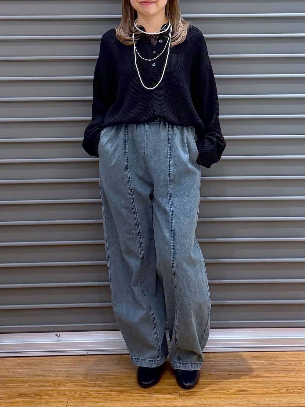 ブラック系のボストンバッグ、ブラック系のパンプス、ブルー系のデニムパンツを着用したレディースの春コーディネートの5枚目の写真