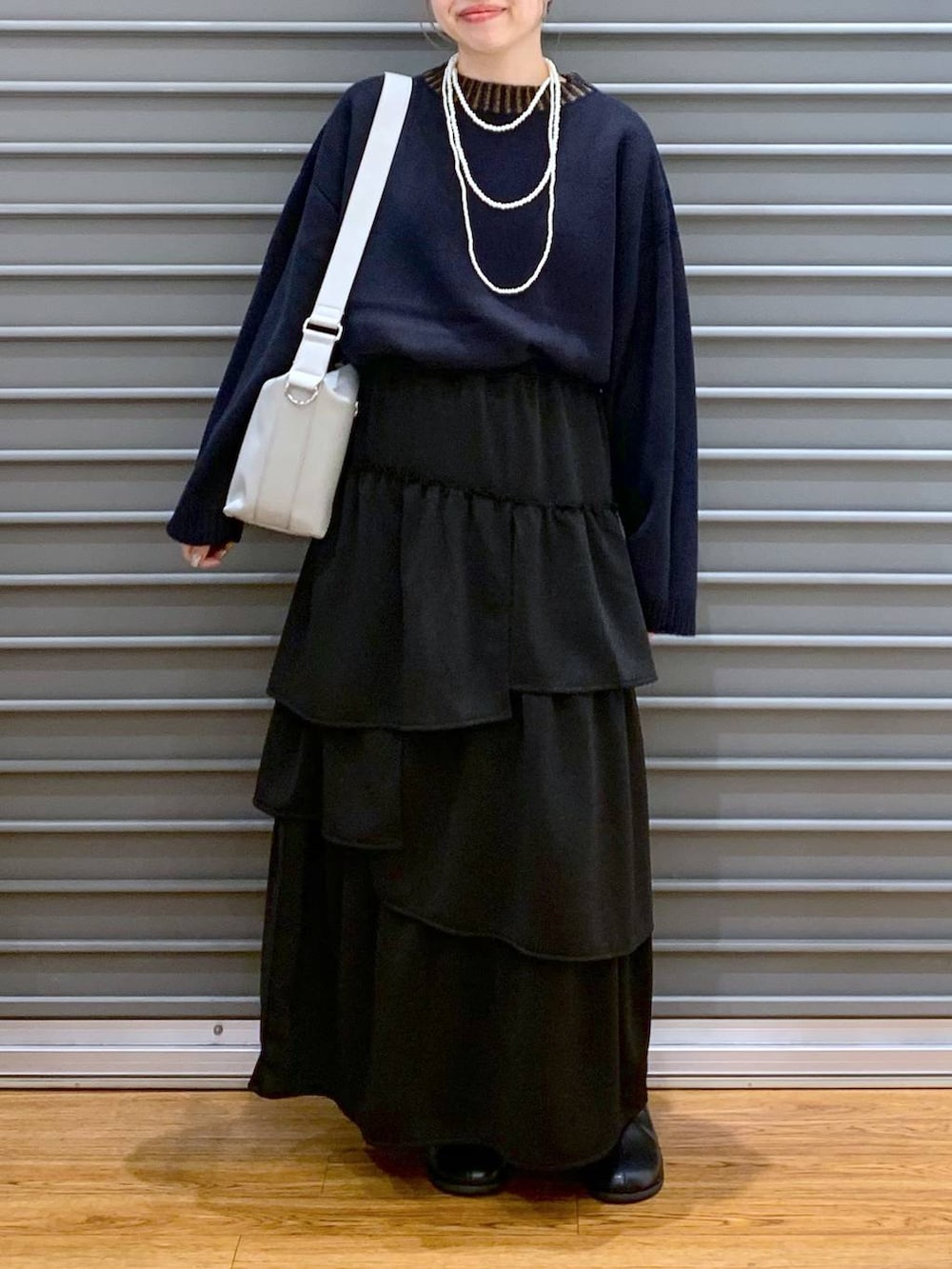 ブルー系のニット/セーター、グレー系のショルダーバッグ、ブラック系のブーツを着用したレディースの冬コーディネートの5枚目の写真