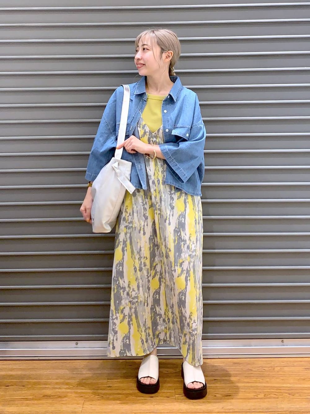 イエロー系のワンピース、ブルー系のシャツ/ブラウス、ホワイト系のサンダルを着用したレディースの夏コーディネートの4枚目の写真