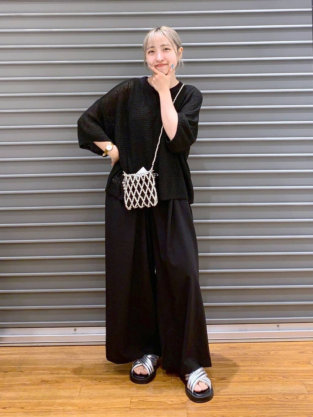 シルバー系のサンダル、ブラック系のスラックス、ブラック系のニット/セーターを着用したレディースの夏コーディネートの3枚目の写真
