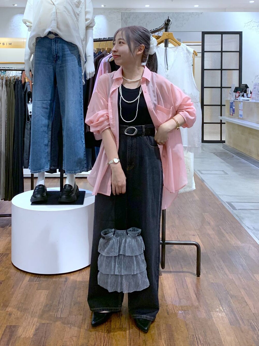 ピンク系のシャツ/ブラウス、ブラック系のデニムパンツ、シルバー系のショルダーバッグを着用したレディースの秋コーディネートの4枚目の写真