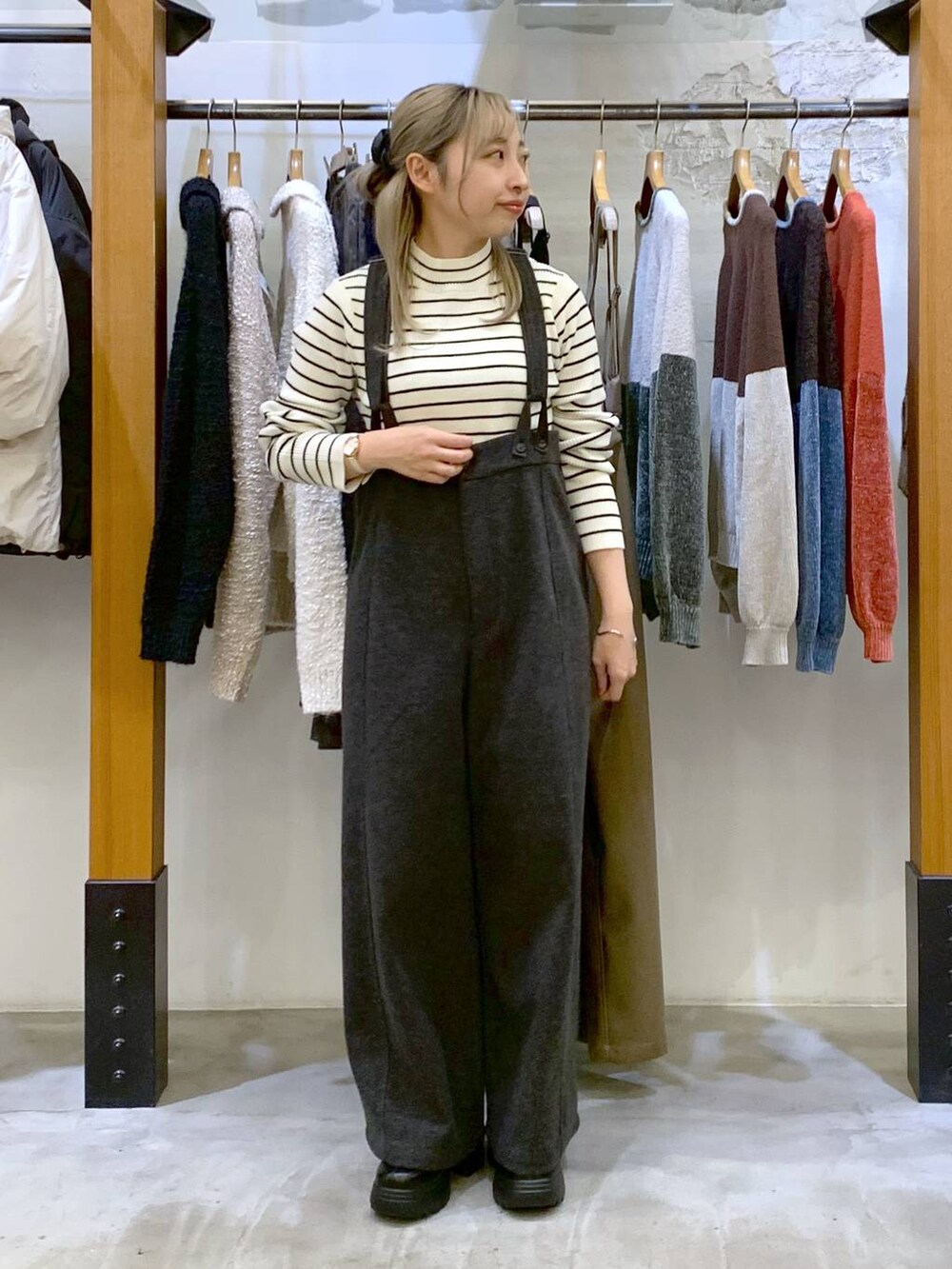グレー系のその他パンツ、ホワイト系のニット/セーター、ブラック系のブーツを着用したレディースの秋コーディネートの6枚目の写真