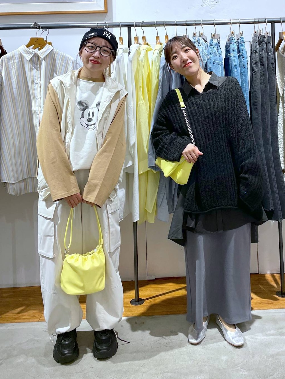 ブラック系のスニーカー、イエロー系のショルダーバッグ、ホワイト系のベストを着用したレディースの春コーディネートの4枚目の写真
