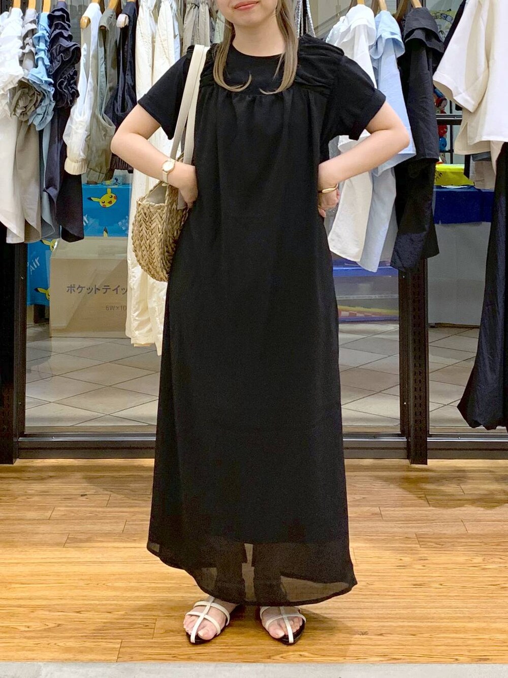 ホワイト系のサンダル、ホワイト系のショルダーバッグ、ブラック系のジャンパースカートを着用したレディースの夏コーディネートの5枚目の写真