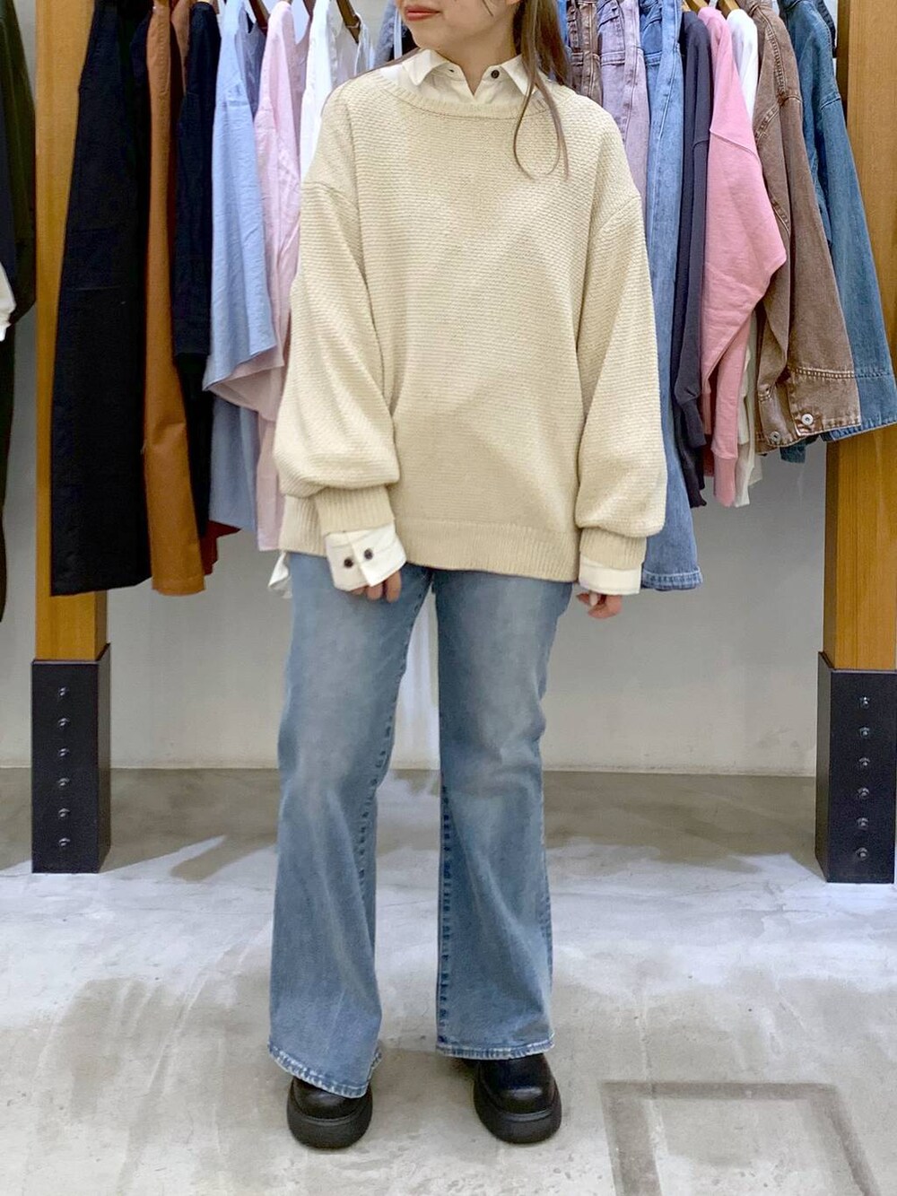ホワイト系のショルダーバッグ、ホワイト系のニット/セーター、ブルー系のデニムパンツを着用したレディースの春コーディネートの5枚目の写真