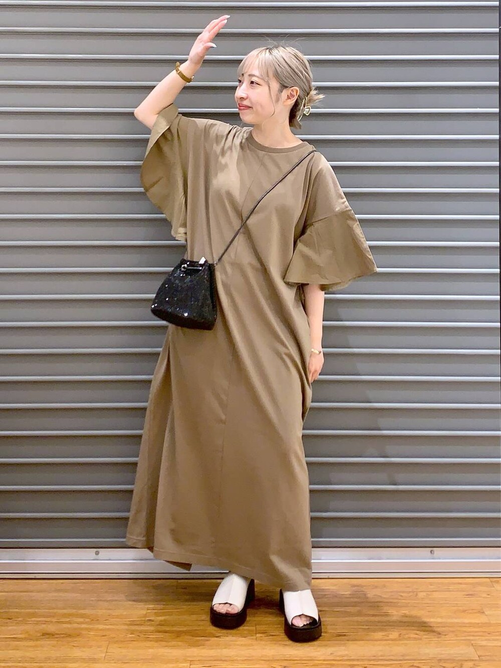 ブラック系のショルダーバッグ、ホワイト系のサンダル、ベージュ系のワンピースを着用したレディースの夏コーディネートの4枚目の写真