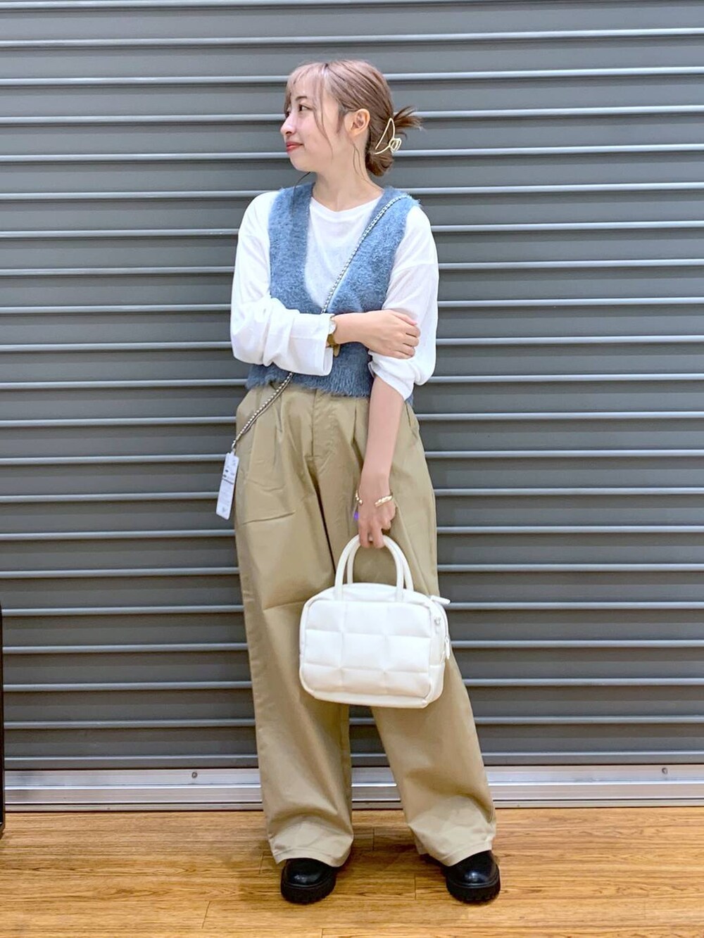 ホワイト系のTシャツ/カットソー、ブラック系のブーツ、ブルー系のベストを着用したレディースの秋コーディネートの3枚目の写真