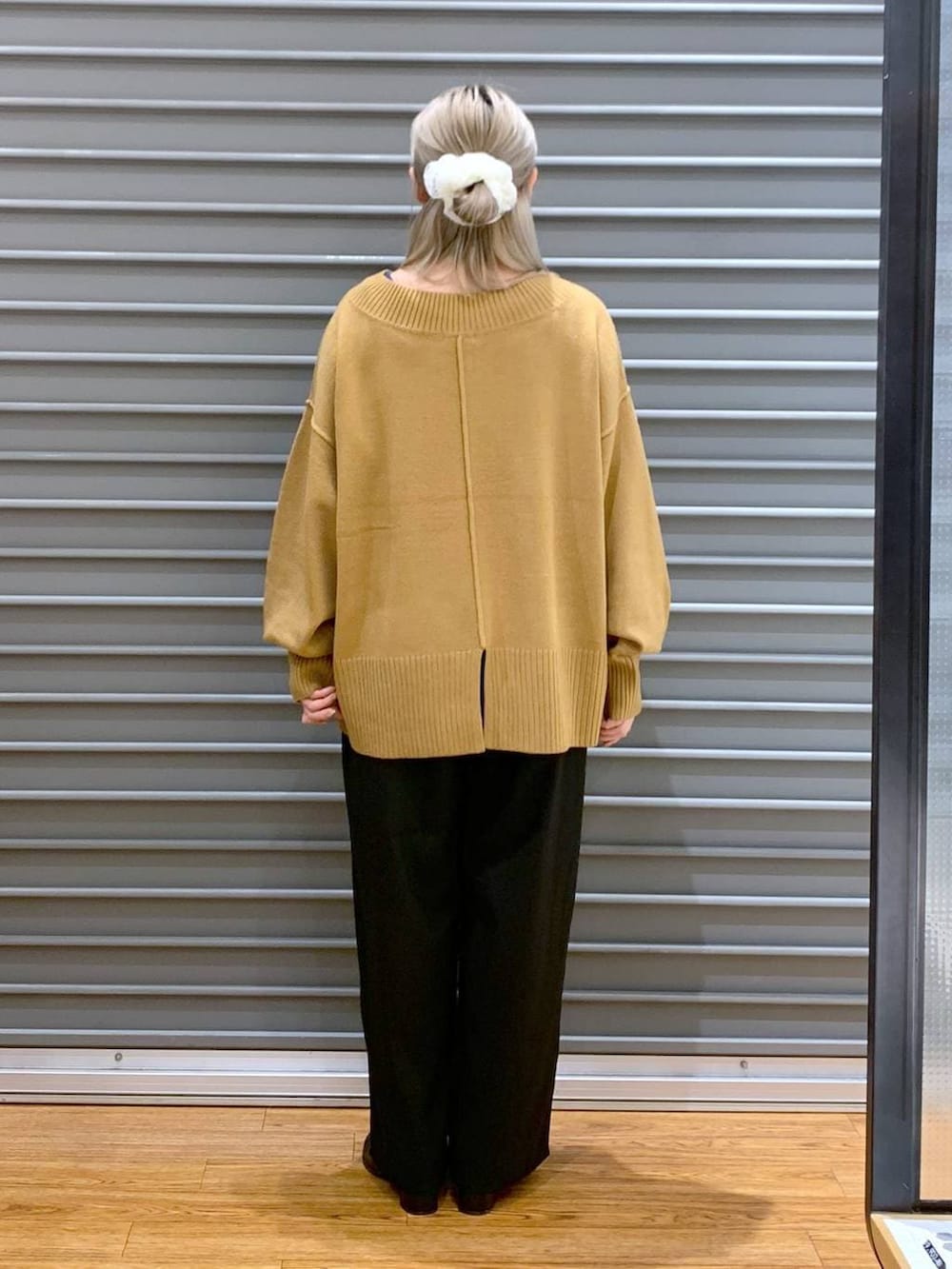 イエロー系のニット/セーター、ブラック系のその他パンツ、グレー系のショルダーバッグを着用したレディースの冬コーディネートの2枚目の写真