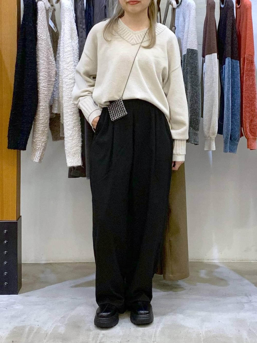 ブラック系のその他パンツ、ホワイト系のニット/セーター、ブラック系のブーツを着用したレディースの冬コーディネートの4枚目の写真