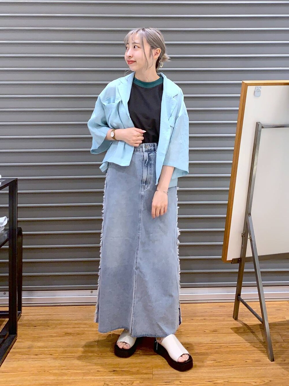 グレー系のタンクトップ、グレー系のショルダーバッグ、ホワイト系のサンダルを着用したレディースの夏コーディネートの5枚目の写真