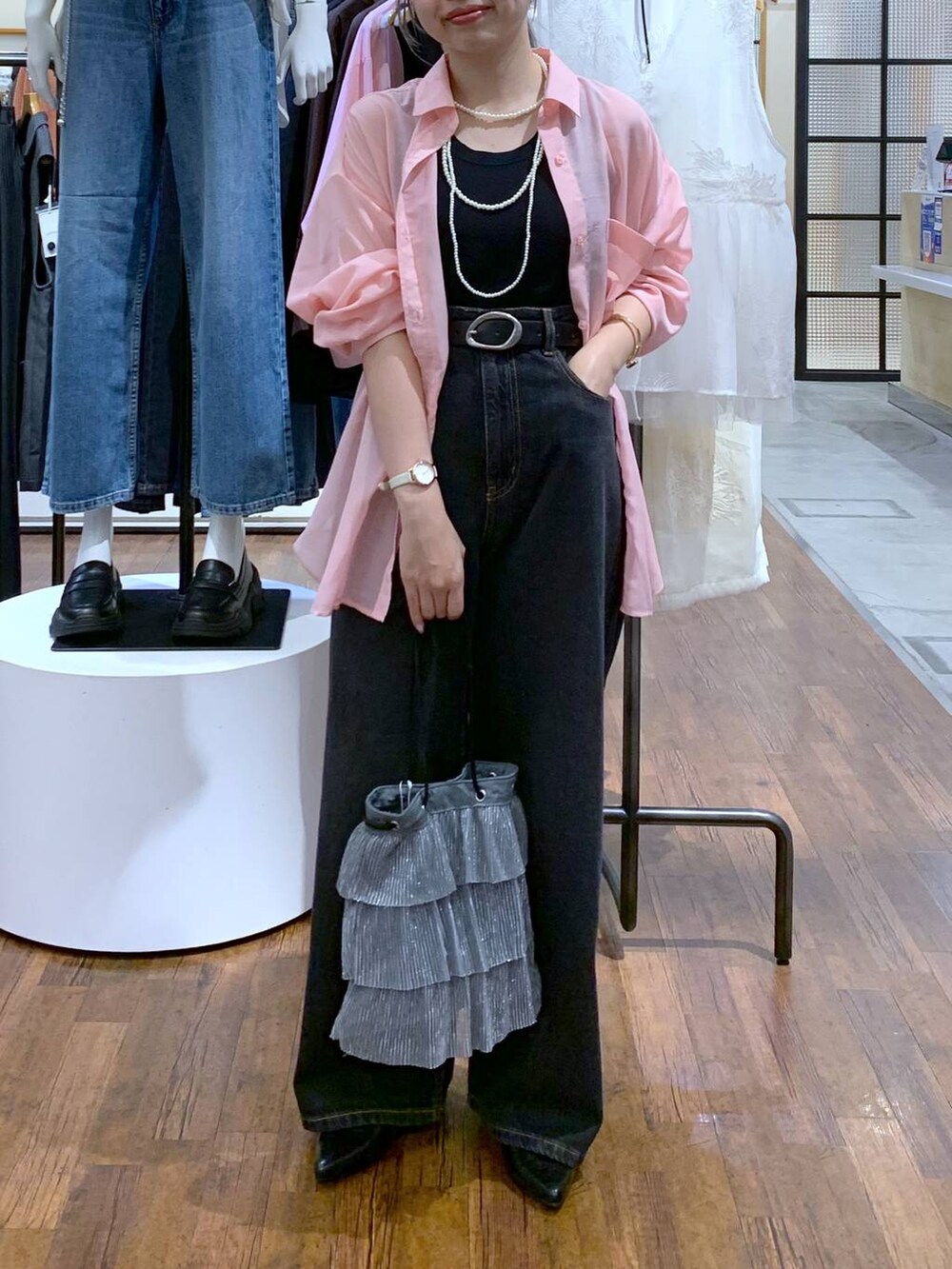 ピンク系のシャツ/ブラウス、ブラック系のデニムパンツ、シルバー系のショルダーバッグを着用したレディースの秋コーディネートの5枚目の写真