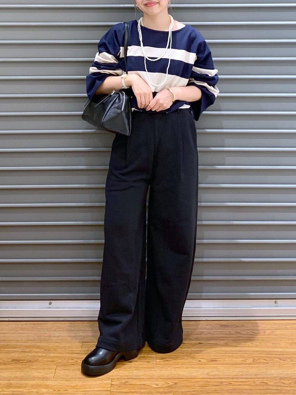 ブラック系のスウェットパンツ、ブラック系のサンダル、ブルー系のTシャツ/カットソーを着用したレディースの秋コーディネートの5枚目の写真