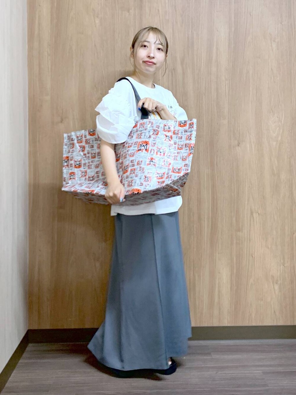 グレー系のスカート、グレー系のトートバッグ、ブラック系のサンダルを着用したレディースの夏コーディネートの5枚目の写真