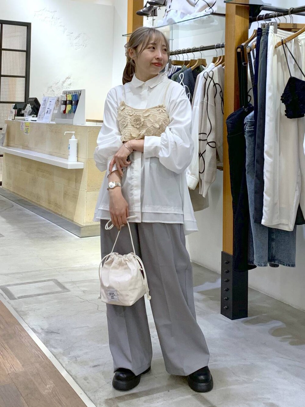 グレー系のその他パンツ、ホワイト系のその他トップス、ホワイト系のショルダーバッグを着用したレディースの春コーディネートの6枚目の写真