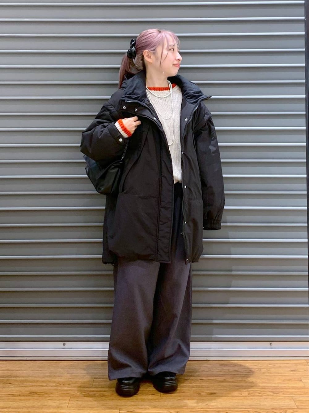 ブラック系のその他アウター、ブラック系のブーツ、ブラック系のショルダーバッグを着用したレディースの冬コーディネートの6枚目の写真