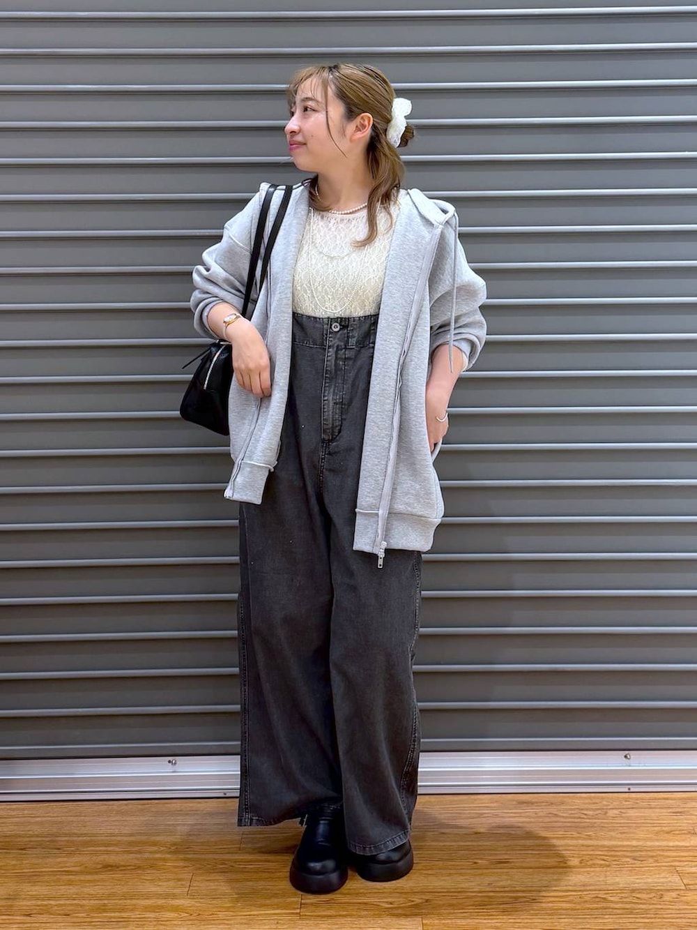 ブラック系のサンダル、ブラック系のボストンバッグ、グレー系のパーカーを着用したレディースの春コーディネートの5枚目の写真