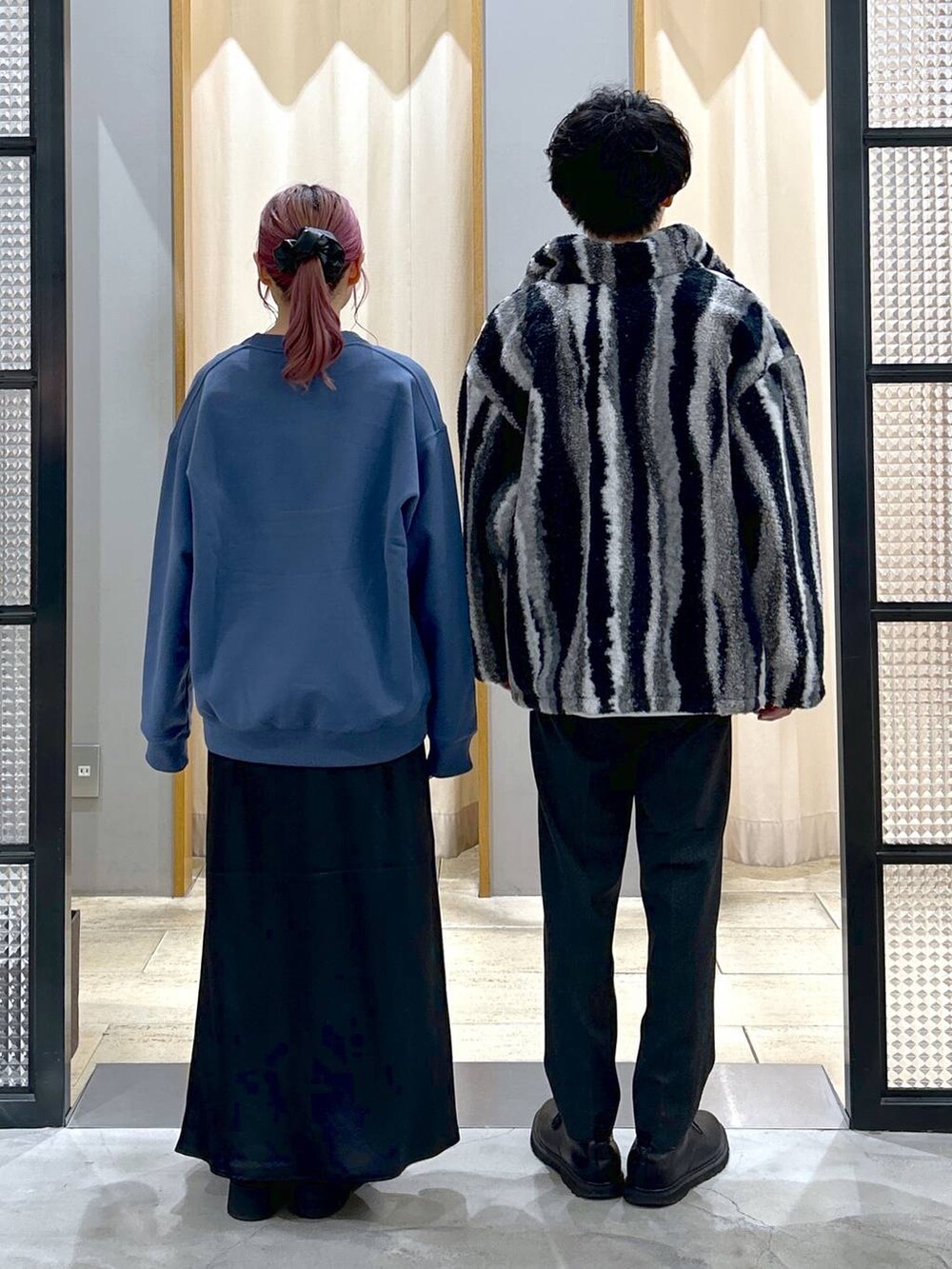 グレー系のスラックス、ホワイト系のスウェット、ブルー系のスウェットを着用したレディースの冬コーディネートの2枚目の写真