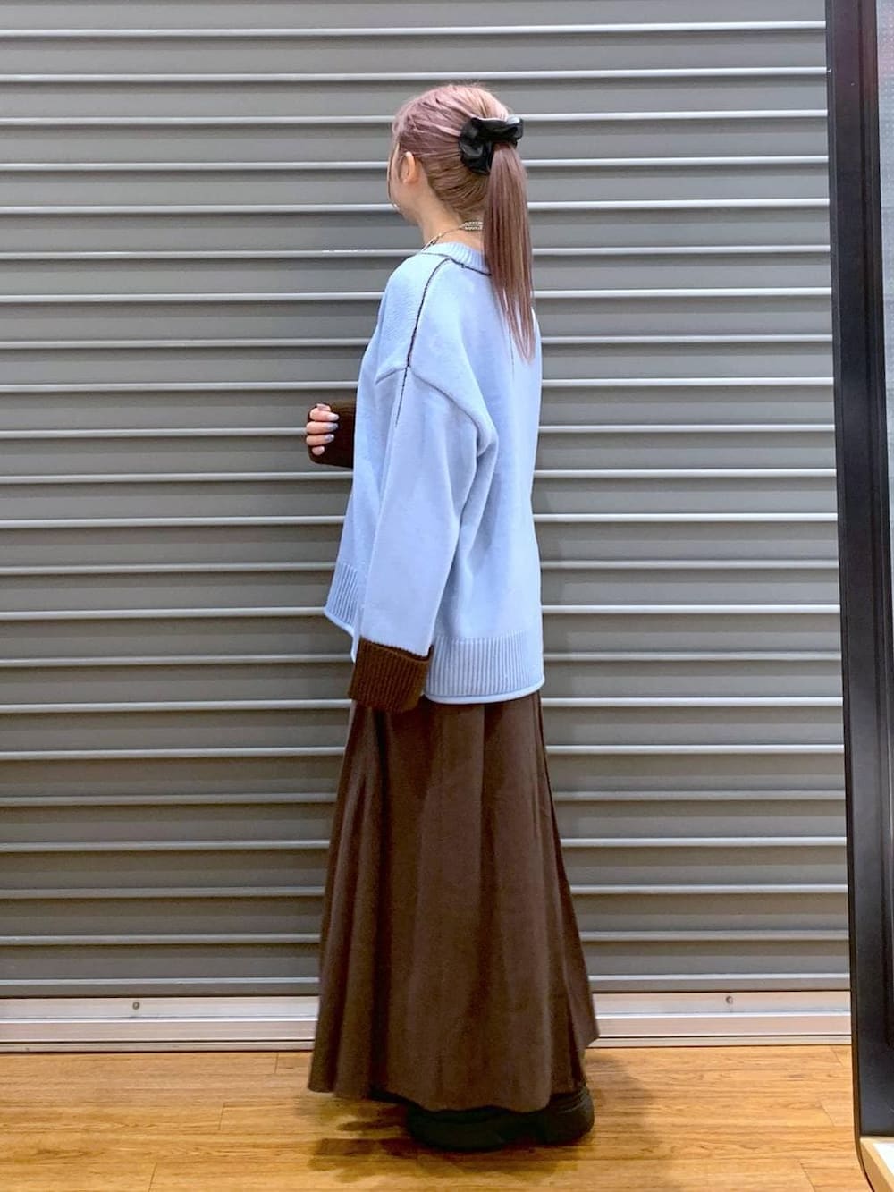 ブラック系のボストンバッグ、ブラック系のブーツ、ブラウン系のスカートを着用したレディースの冬コーディネートの3枚目の写真