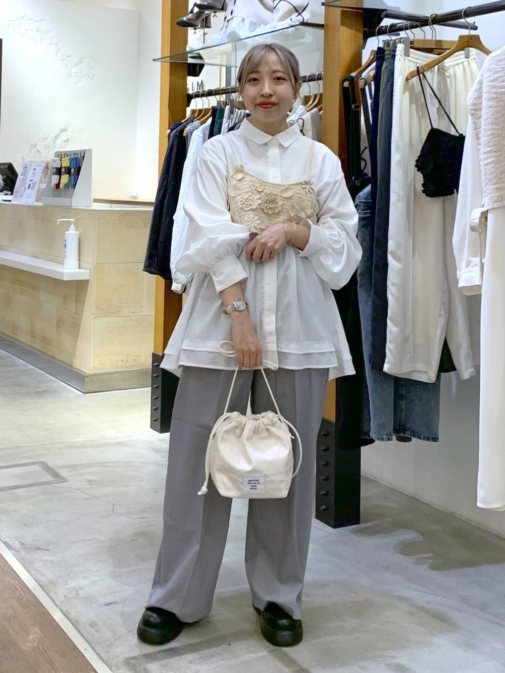 グレー系のその他パンツ、ホワイト系のその他トップス、ホワイト系のショルダーバッグを着用したレディースの春コーディネートの4枚目の写真