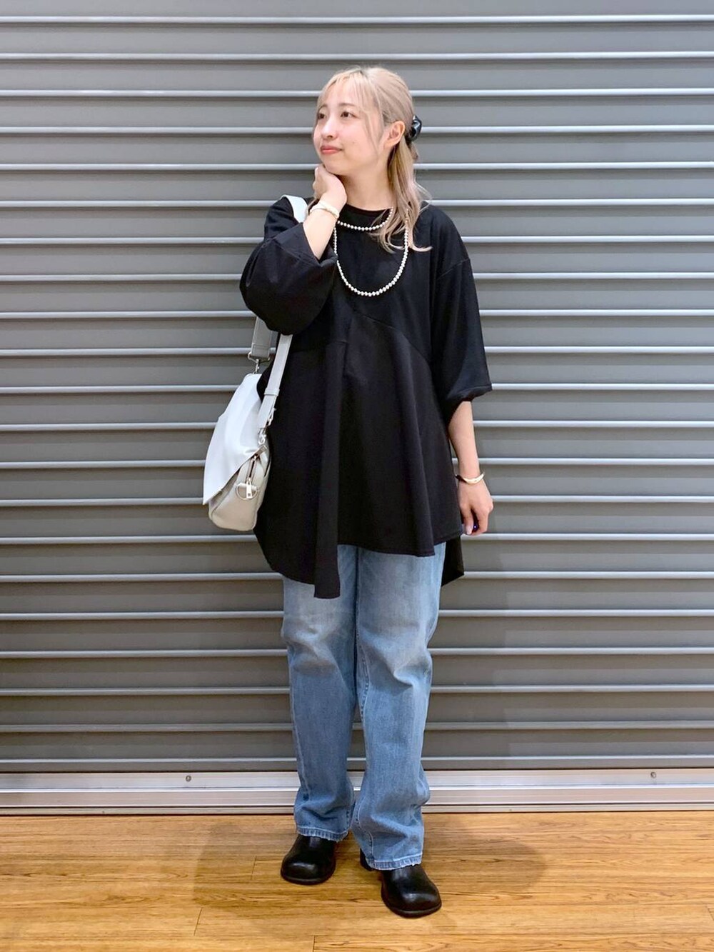 ブルー系のデニムパンツ、グレー系のショルダーバッグ、ブラック系のその他シューズを着用したレディースの秋コーディネートの4枚目の写真