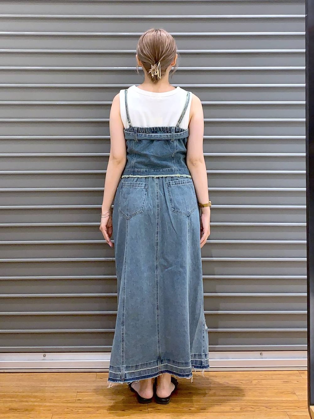 シルバー系のショルダーバッグ、ブラック系のサンダル、ホワイト系のタンクトップを着用したレディースの夏コーディネートの2枚目の写真