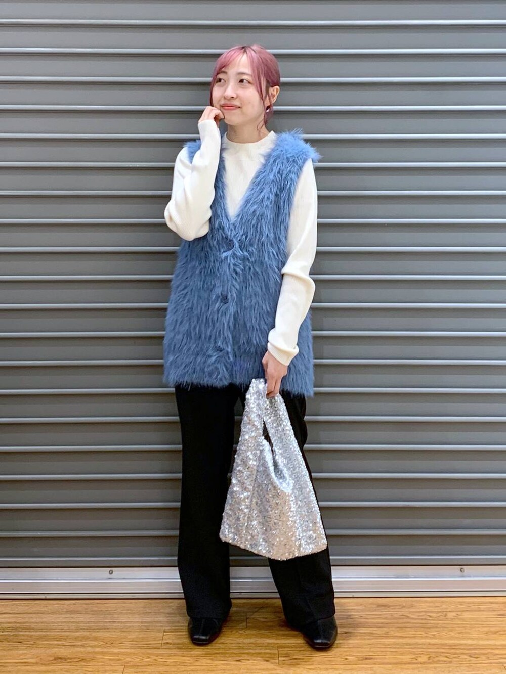 ホワイト系のニット/セーター、ブラック系のブーツ、ブルー系のベストを着用したレディースの秋コーディネートの6枚目の写真