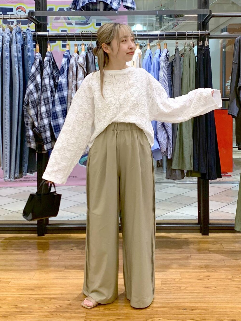 ブラック系のショルダーバッグ、ベージュ系のその他パンツ、ホワイト系のTシャツ/カットソーを着用したレディースの春コーディネートの4枚目の写真