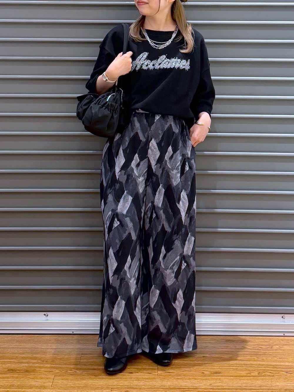 グレー系のその他パンツ、ブラック系のボストンバッグ、ブラック系のパンプスを着用したレディースの春コーディネートの5枚目の写真