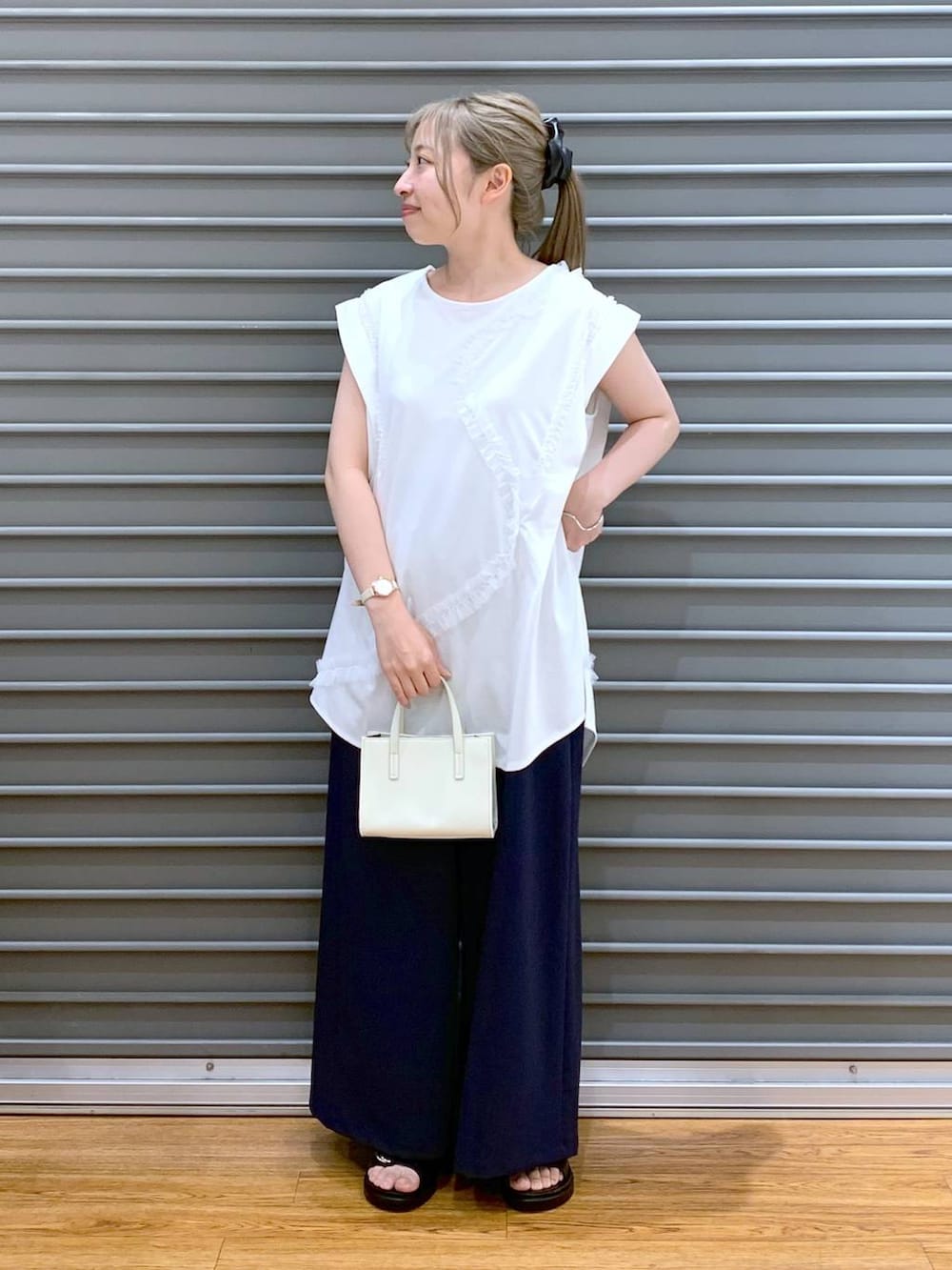 ブラック系のサンダル、ブルー系のその他パンツ、ホワイト系のショルダーバッグを着用したレディースの夏コーディネートの4枚目の写真