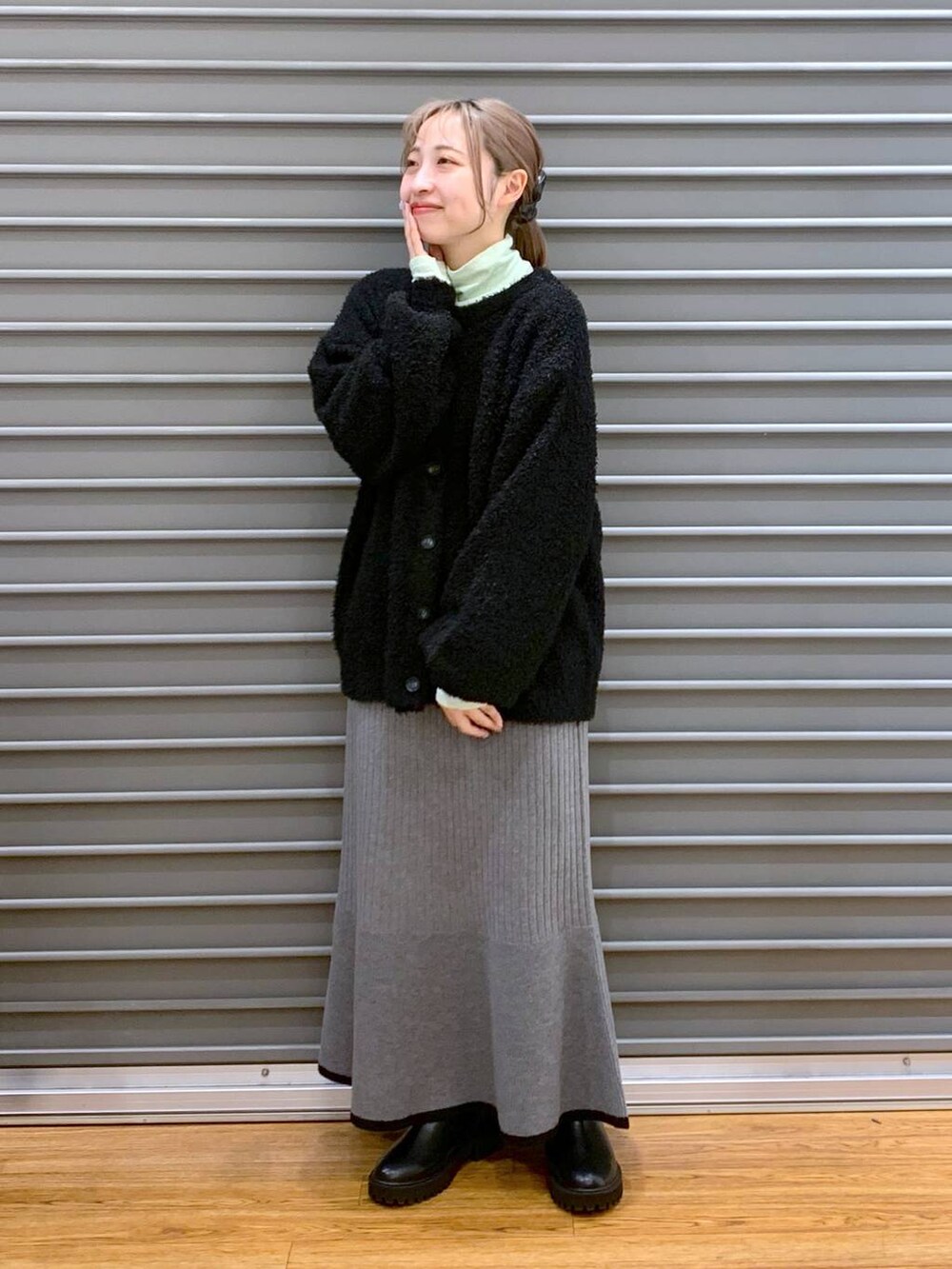 ブラック系のブーツ、ブラック系のワンピース、グリーン系のTシャツ/カットソーを着用したレディースの冬コーディネートの7枚目の写真