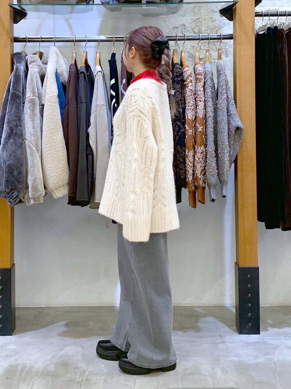 レッド系のTシャツ/カットソー、ブラック系のブーツ、ブラック系のショルダーバッグを着用したレディースの冬コーディネートの3枚目の写真