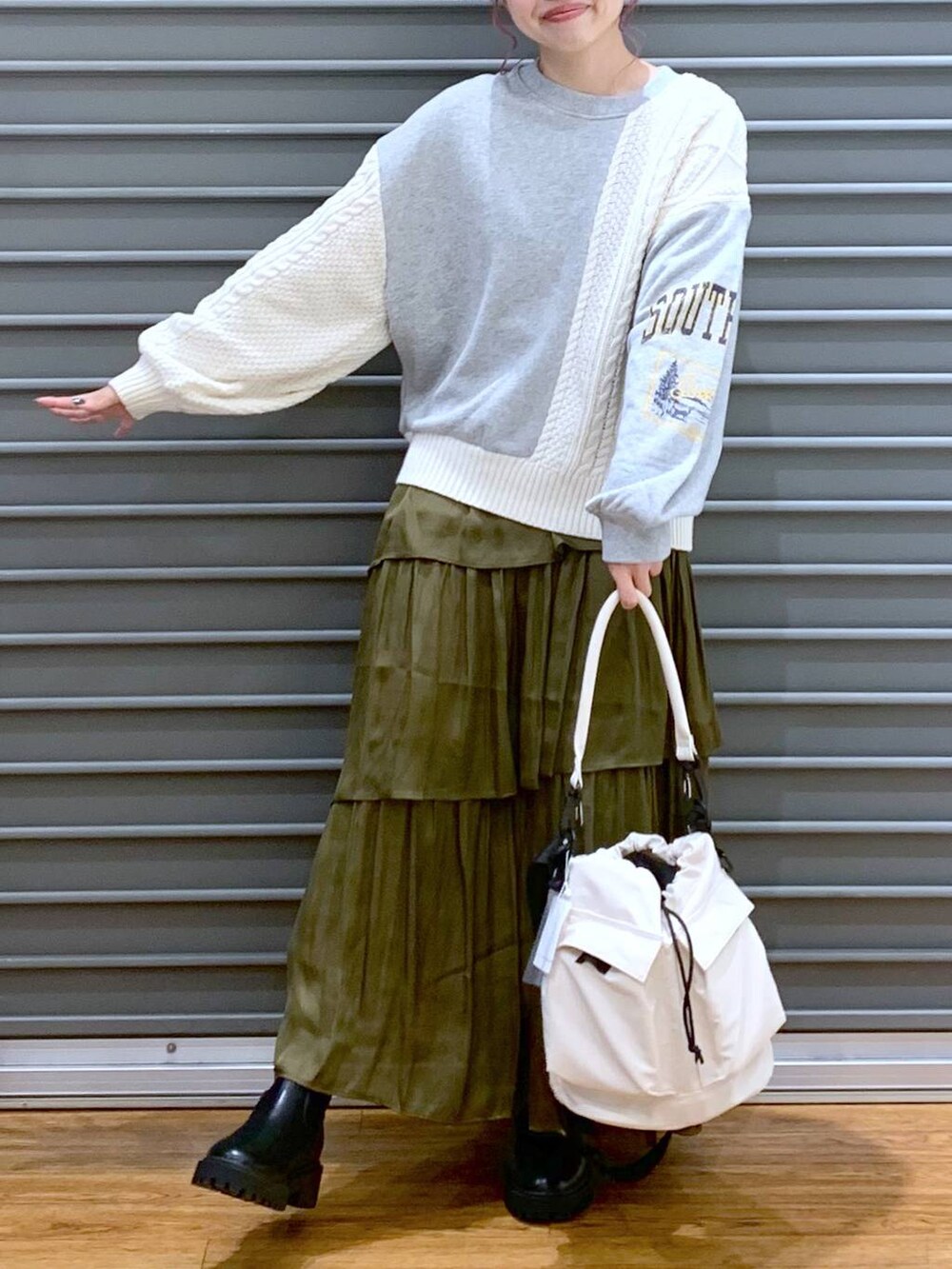 ホワイト系のショルダーバッグ、ブラック系のブーツ、グレー系のニット/セーターを着用したレディースの秋コーディネートの5枚目の写真