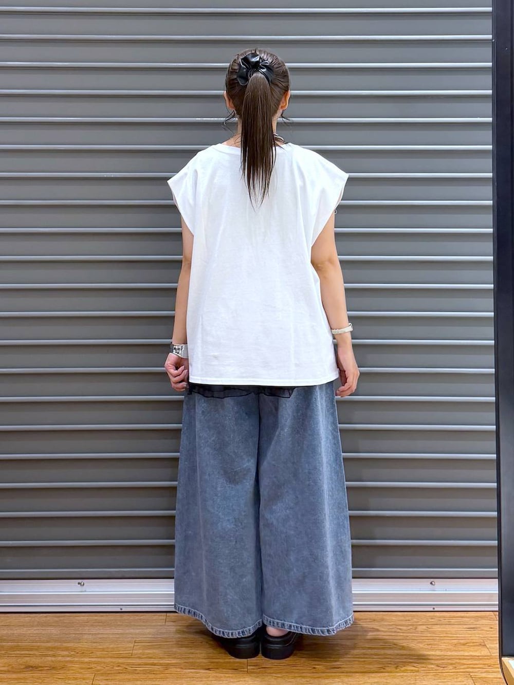 パープル系のトートバッグ、ホワイト系のサンダル、ホワイト系のTシャツ/カットソーを着用したレディースの夏コーディネートの2枚目の写真
