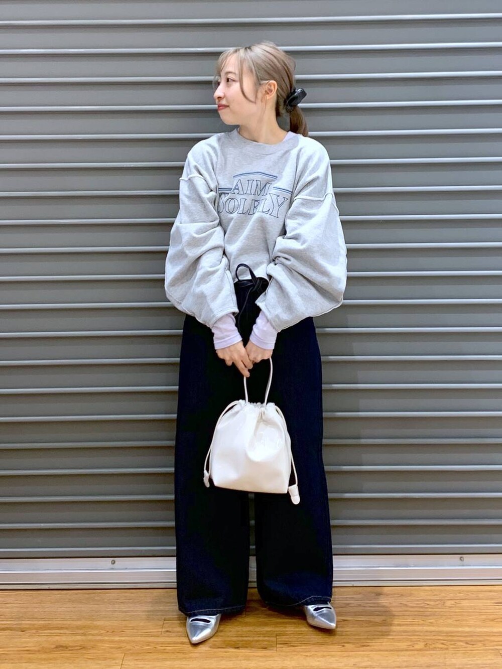 パープル系のTシャツ/カットソー、ブルー系のデニムパンツ、シルバー系のパンプスを着用したレディースの冬コーディネートの4枚目の写真