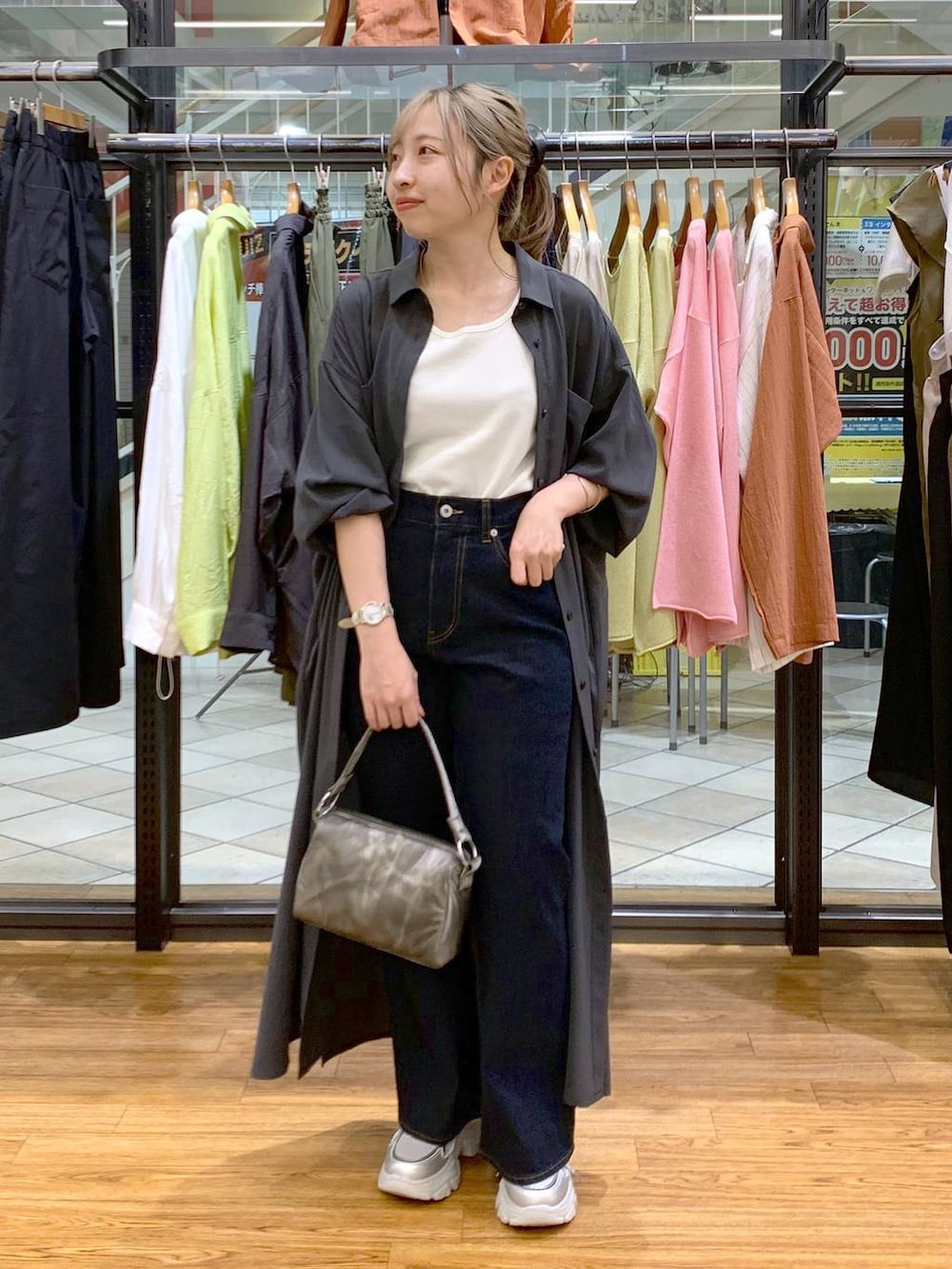 グレー系のワンピース、ホワイト系のタンクトップ、ブルー系のデニムパンツを着用したレディースの春コーディネートの4枚目の写真