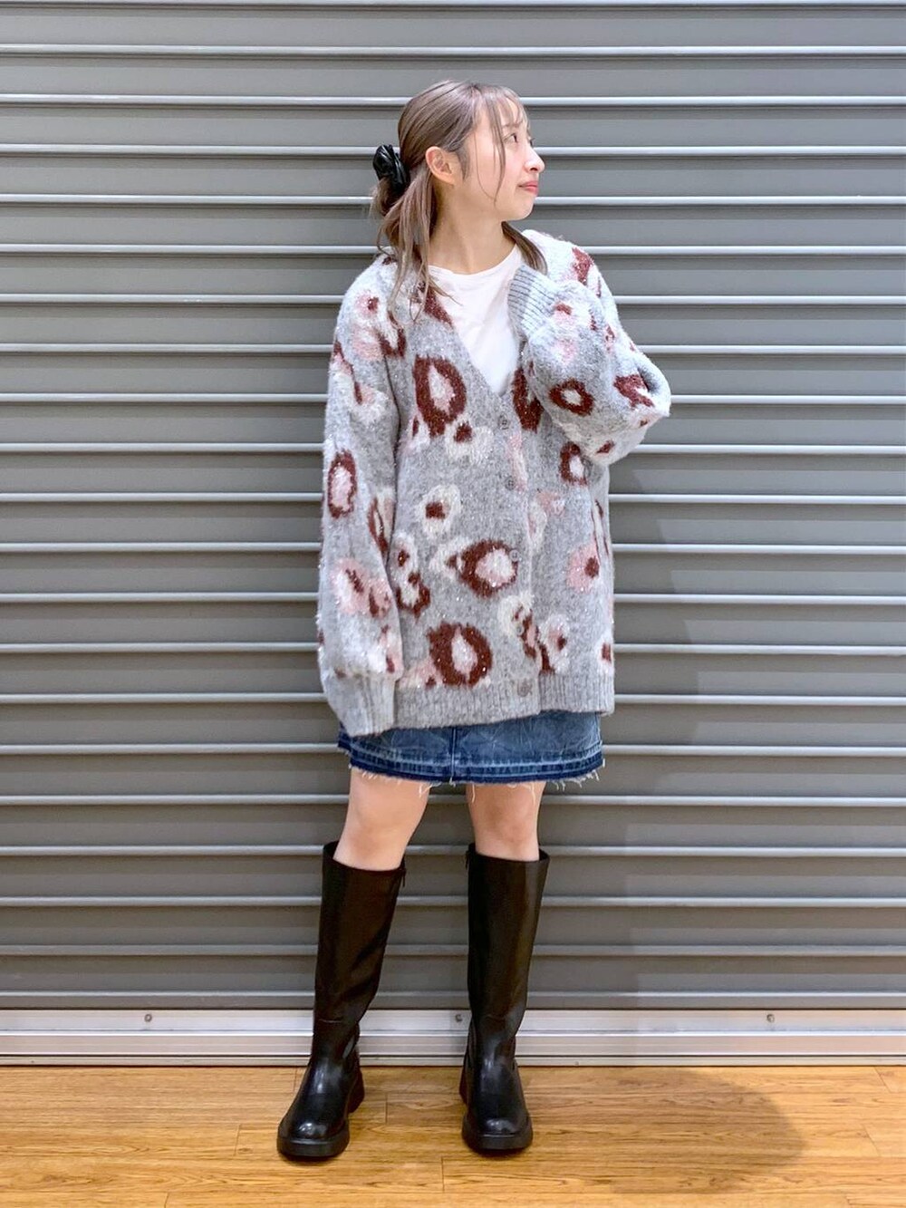 ブルー系のデニムスカート、ブラック系のショルダーバッグ、ブラック系のブーツを着用したレディースの冬コーディネートの6枚目の写真