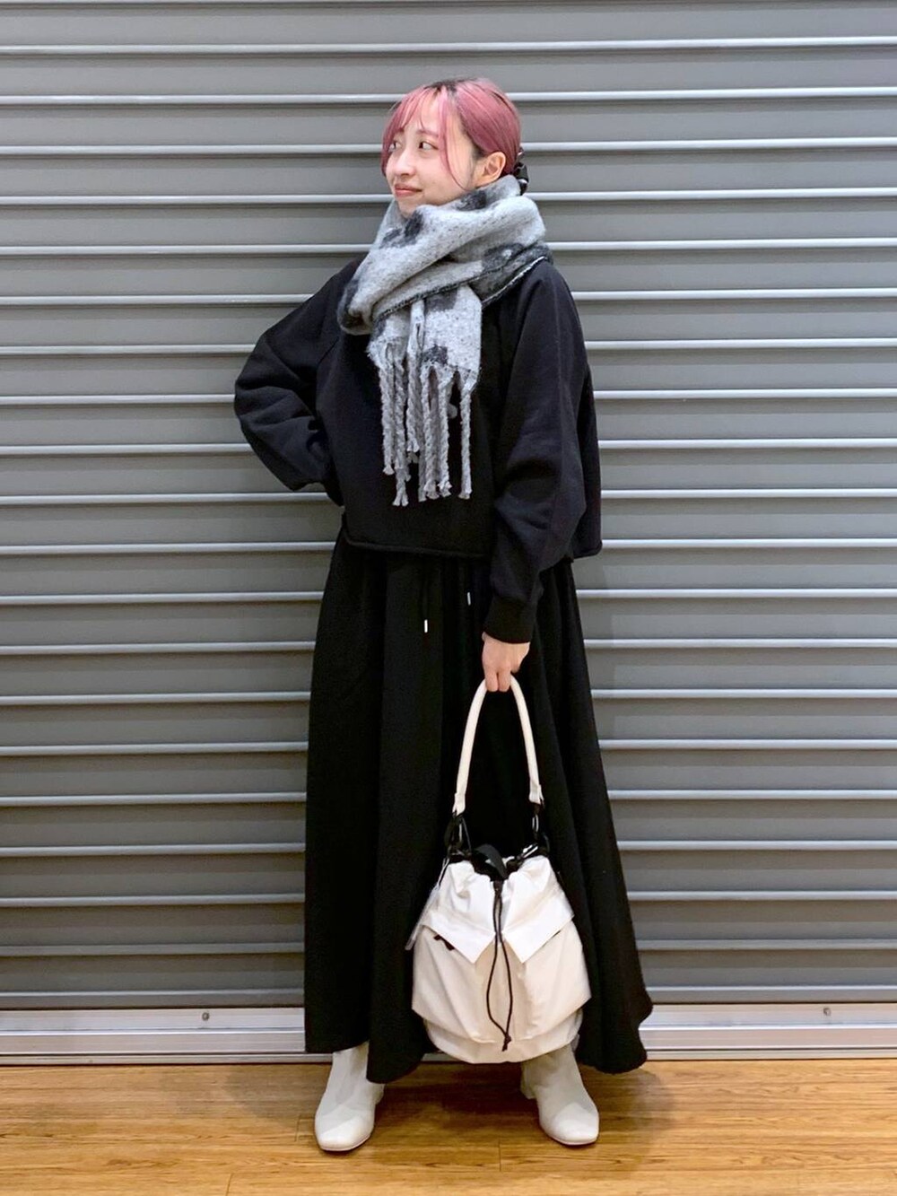 ホワイト系のショルダーバッグ、ホワイト系のブーツ、ブラック系のその他パンツを着用したレディースの秋コーディネートの4枚目の写真