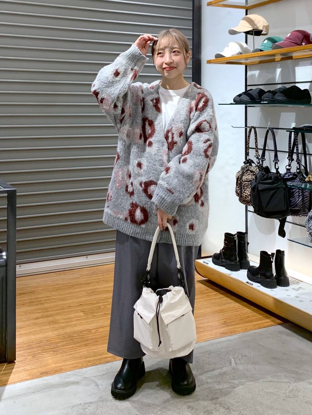 ホワイト系のショルダーバッグ、ブラック系のブーツ、ブラック系のスカートを着用したレディースの冬コーディネートの3枚目の写真