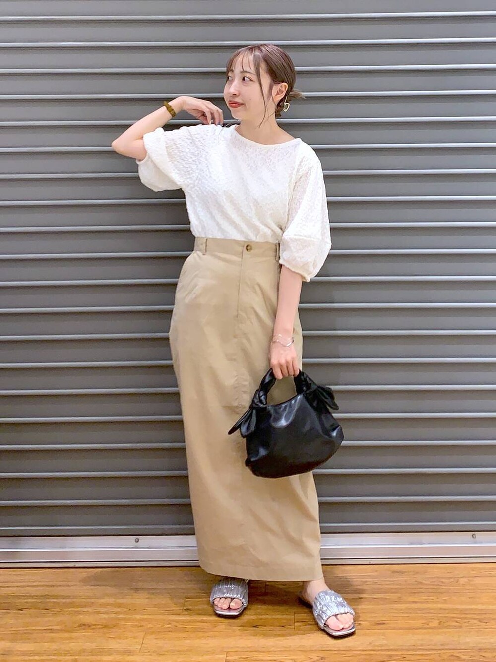 ホワイト系のTシャツ/カットソー、ベージュ系のスカート、ブラック系のショルダーバッグを着用したレディースの夏コーディネートの4枚目の写真