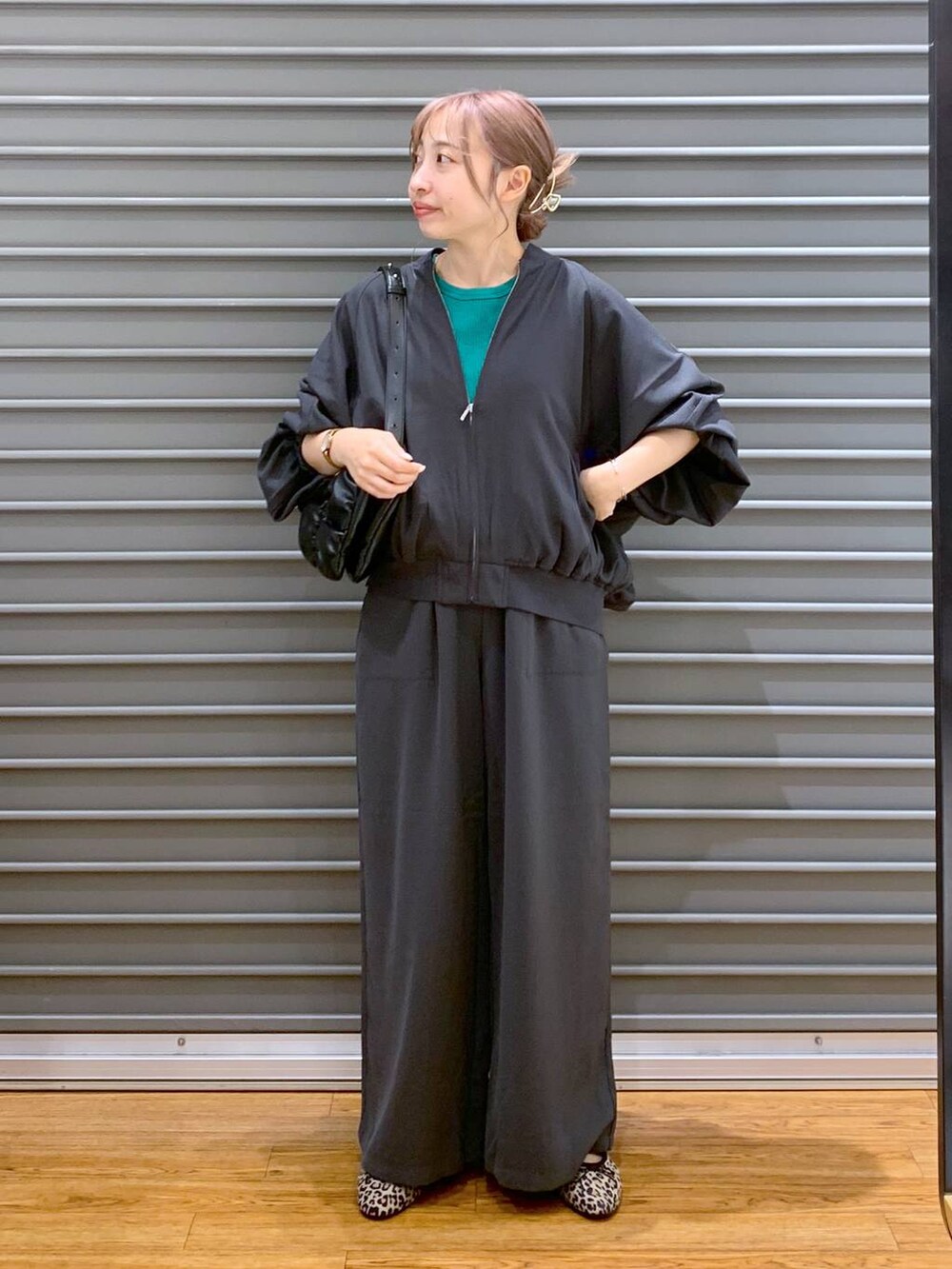 グリーン系のタンクトップ、ブラック系のショルダーバッグ、グレー系のその他パンツを着用したレディースの秋コーディネートの5枚目の写真