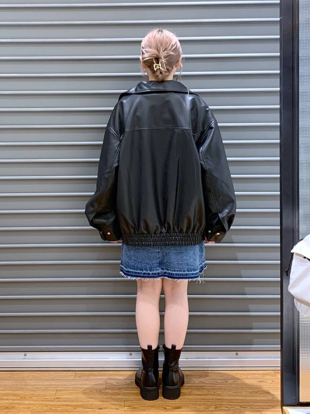 シルバー系のボストンバッグ、ブラック系のブーツ、ブラック系のブルゾンを着用したレディースの秋コーディネートの2枚目の写真